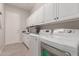 Clean laundry room featuring washer, dryer, and white cabinets at 450 E Alamosa Dr, Chandler, AZ 85249