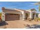 Charming exterior featuring a tile roof, solar panels, a three-car garage and a brick driveway at 4684 N 206Th Ave, Buckeye, AZ 85396