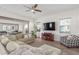 Open-concept living room features a sectional sofa, a ceiling fan, and sliding glass doors to an outdoor space at 4684 N 206Th Ave, Buckeye, AZ 85396