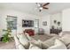 Bright living room featuring a cozy sectional sofa, large TV, and modern ceiling fan at 4684 N 206Th Ave, Buckeye, AZ 85396