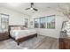 Relaxing main bedroom features wood floors, a ceiling fan, and views of the lovely neighborhood at 4684 N 206Th Ave, Buckeye, AZ 85396