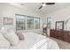 Light-filled main bedroom with a ceiling fan, wood flooring, and abundant natural light at 4684 N 206Th Ave, Buckeye, AZ 85396