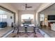 Covered patio features a dining table, seating, ceiling fan and an archway leading to an outdoor fireplace at 4684 N 206Th Ave, Buckeye, AZ 85396