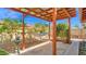 Tranquil backyard featuring a cozy hammock under a wooden pergola, surrounded by lush greenery at 5216 W Beryl Ave, Glendale, AZ 85302