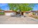 Charming single-story home featuring a brick facade, mature shade tree, and a two-car garage at 5216 W Beryl Ave, Glendale, AZ 85302