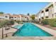 Community pool surrounded by condos, with lush landscaping and lounge chairs at 5249 E Shea Blvd # 214, Scottsdale, AZ 85254