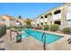 Community pool with a spa tub, surrounded by condos, lush landscaping, and lounge chairs at 5249 E Shea Blvd # 214, Scottsdale, AZ 85254