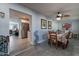 Dining room with a floral tablecloth and decorative ceiling fan, flows into the kitchen and living room at 555 Leisure World --, Mesa, AZ 85206