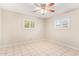 Neutral bedroom with tile flooring, ceiling fan, and two windows providing natural light at 5618 E Des Moines St, Mesa, AZ 85205