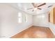 Light-filled bedroom with laminate flooring, dual windows and light ceiling fan at 5618 E Des Moines St, Mesa, AZ 85205