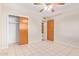 Neutral bedroom featuring tile floors, closet, and standard ceiling fan with light fixture at 5618 E Des Moines St, Mesa, AZ 85205