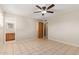 Neutral bedroom with tile flooring leading to a door, and an open bathroom featuring wood cabinets at 5618 E Des Moines St, Mesa, AZ 85205