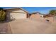 View of house exterior showcasing a large driveway, desert landscaping, and an attached garage at 5618 E Des Moines St, Mesa, AZ 85205