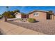 Front exterior featuring low-maintenance desert landscaping, brick accents, and an attached garage at 5618 E Des Moines St, Mesa, AZ 85205