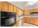 Traditional eat-in kitchen features tile countertops, a white dishwasher, and honey colored wood cabinetry at 5618 E Des Moines St, Mesa, AZ 85205