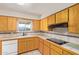 Traditional eat-in kitchen features tile countertops, honey colored wood cabinetry, and a white dishwasher at 5618 E Des Moines St, Mesa, AZ 85205