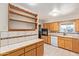 Traditional eat-in kitchen features tile countertops, a white dishwasher, and honey colored wood cabinetry at 5618 E Des Moines St, Mesa, AZ 85205