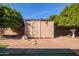 Backyard storage shed adjacent to mature citrus trees and artificial turf at 5618 E Des Moines St, Mesa, AZ 85205