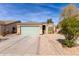 Inviting single-story home with desert landscaping, a green garage door, and a paved walkway at 562 W Enchanted Desert Dr, Casa Grande, AZ 85122