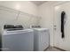 Laundry room with a white washer, dryer, metal shelving, and a closed door at 562 W Enchanted Desert Dr, Casa Grande, AZ 85122