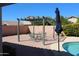 Backyard patio features a pergola with outdoor seating and umbrella, overlooking a sparkling pool at 5624 E Garnet Ave, Mesa, AZ 85206