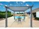 Relaxing backyard featuring a pergola-covered outdoor dining area adjacent to a sparkling pool at 5624 E Garnet Ave, Mesa, AZ 85206