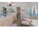 Well-lit bathroom featuring double sinks, a large mirror, and a separate shower and tub at 5624 E Garnet Ave, Mesa, AZ 85206