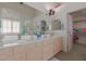 Bright bathroom featuring double sinks, a large mirror, and a walk-in closet at 5624 E Garnet Ave, Mesa, AZ 85206