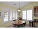 Charming breakfast nook featuring plantation shutters, a wood table, and a hanging pendant light at 5624 E Garnet Ave, Mesa, AZ 85206