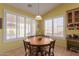 Well-lit dining area featuring a round table, a pendant light, and plantation shutters at 5624 E Garnet Ave, Mesa, AZ 85206