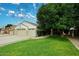 Well-maintained home with a lush green lawn and an attached three-car garage at 5624 E Garnet Ave, Mesa, AZ 85206