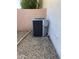 Air conditioning unit on a gravel area next to a stucco wall with piping at 5624 E Garnet Ave, Mesa, AZ 85206