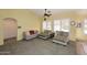 Cozy living room with neutral sofas, carpet flooring, windows with shutters, and a ceiling fan at 5624 E Garnet Ave, Mesa, AZ 85206