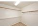 Empty walk-in closet with basic wood shelving and wooden rods, ready for organization at 5624 E Garnet Ave, Mesa, AZ 85206