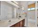 Bright bathroom featuring double sinks, a wide mirror, and a glimpse into the shower/tub through an open doorway at 5634 N 82 Ave, Glendale, AZ 85303