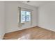 Bright bedroom featuring hardwood floors, a large window, and neutral wall paint at 5634 N 82 Ave, Glendale, AZ 85303