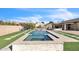 Backyard pool and spa with artificial turf, a tanning ledge, and surrounding hardscape at 5634 N 82 Ave, Glendale, AZ 85303