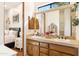 Charming bathroom featuring a double vanity with wood cabinets and a view into the main bedroom at 6432 E Old Paint Trl, Carefree, AZ 85377