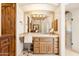 Bathroom vanity area featuring stone countertops and a decorative mirror with stylish light fixture at 6432 E Old Paint Trl, Carefree, AZ 85377