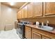 Spacious laundry room featuring granite countertops, sink, and modern washer and dryer at 6432 E Old Paint Trl, Carefree, AZ 85377