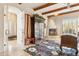 Inviting living room featuring a decorative fireplace, wooden beams and access to multiple rooms at 6432 E Old Paint Trl, Carefree, AZ 85377