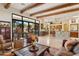 Open-concept living room with a stone accent wall, travertine flooring, and seamless access to the outdoor patio and kitchen at 6432 E Old Paint Trl, Carefree, AZ 85377