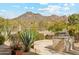 Beautiful backyard setting featuring an outdoor kitchen, lush greenery, and scenic views of the surrounding mountains at 6432 E Old Paint Trl, Carefree, AZ 85377