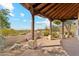 Covered outdoor patio showcasing natural wood pillars and desert views, perfect for enjoying the tranquil scenery at 6432 E Old Paint Trl, Carefree, AZ 85377