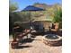 Back patio with desert views, featuring comfortable seating, fire pit, and landscaping at 6432 E Old Paint Trl, Carefree, AZ 85377