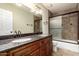 Bathroom features a double sink vanity, granite countertop, and tiled shower with glass door at 6543 E Preston St, Mesa, AZ 85215