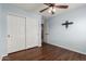 Well-lit bedroom with a ceiling fan, closet, and wood-look flooring at 6543 E Preston St, Mesa, AZ 85215