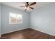 Relaxing bedroom with wood floors, a ceiling fan, and a window overlooking the neighborhood at 6543 E Preston St, Mesa, AZ 85215