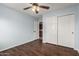 Comfortable bedroom featuring wood floors, a ceiling fan, and closet with ample storage space at 6543 E Preston St, Mesa, AZ 85215