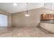 Open floor plan with tile flooring and modern light fixtures, connecting the living room and kitchen at 6543 E Preston St, Mesa, AZ 85215